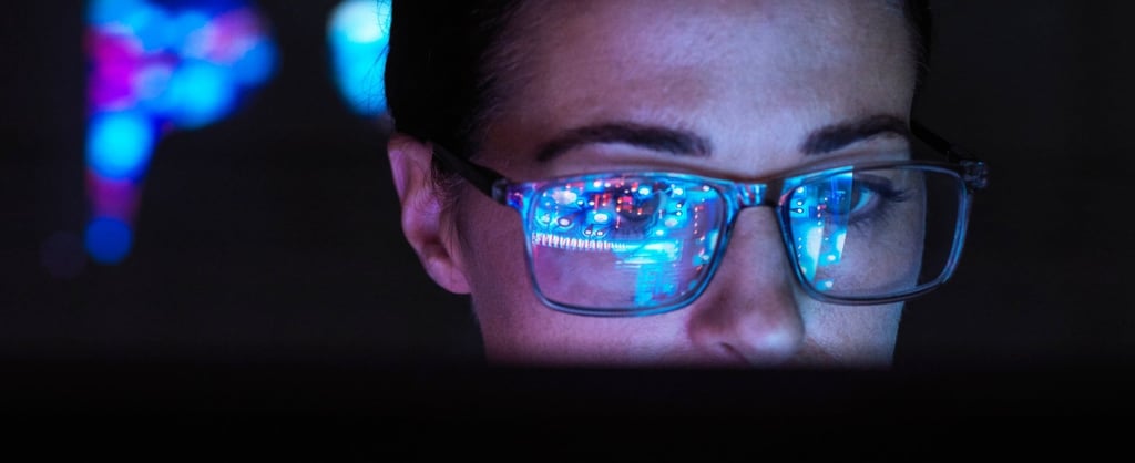 Woman with glasses looking at laptop - 1920x785